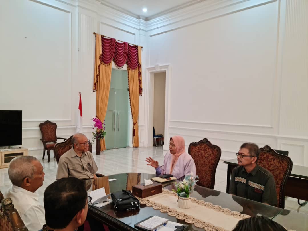 Team of engineers discussing project plans in a modern office with blueprints on the table